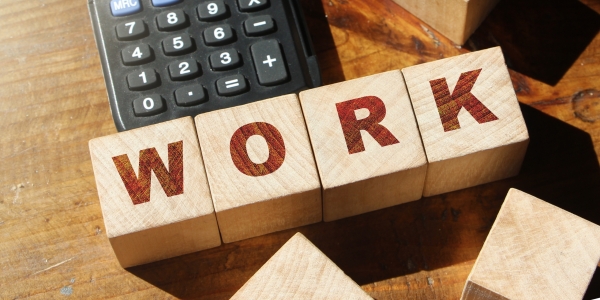 Work,Word,Made,With,Wooden,Blocks,On,Desk,With,Calculator.